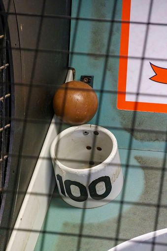 A skee-ball is wedged stuck by the 100 point (highest score) hole