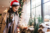 クリスマスマーケットで買い物をしている幸せな若い女性