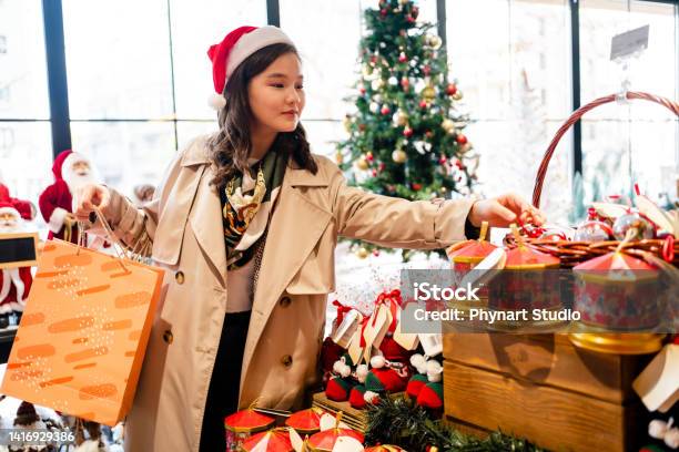 クリスマスマーケットで買い物をしている幸せな若い女性