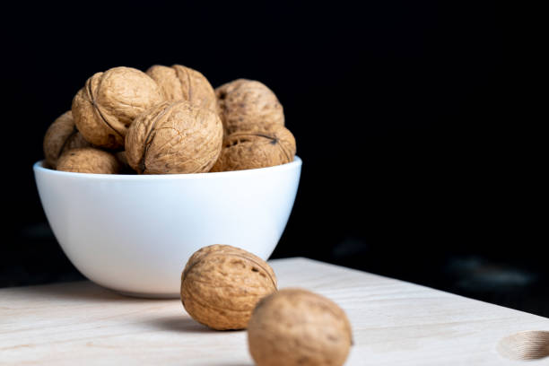 istock Walnuts in a white bowl on a wooden table 1416933555