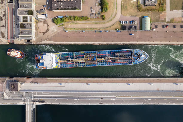 lng-schiff fährt mit lotsenboot in die kanalschleuse ein - piloting commercial dock harbor industrial ship stock-fotos und bilder