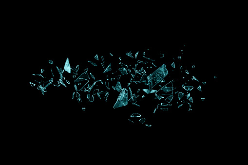 Small pieces of broken blue glass isolated on black background. Texture of broken glass. Isolated realistic cracked glass effect.