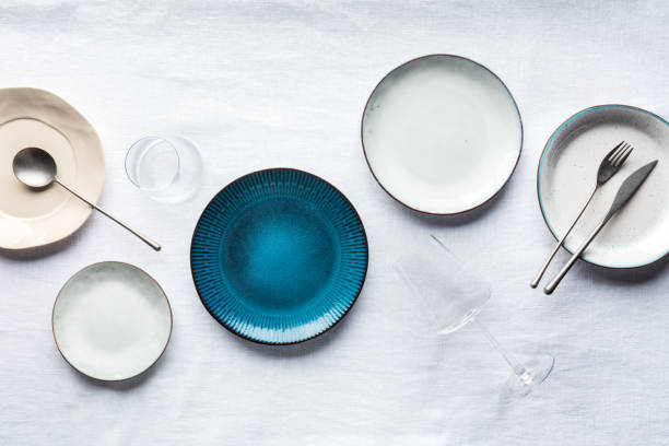 Modern tableware set with cutlery, glasses, and a vibrant blue plate