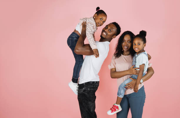 istock Cheerful father and mom carrying their daughters on hands. 1416943736