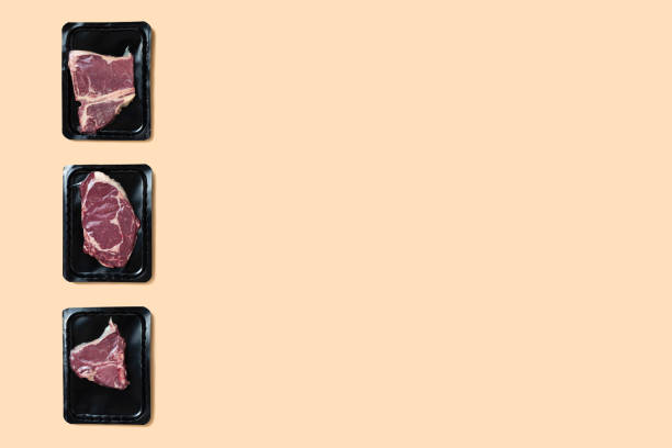 Raw fresh meat in vacuum-packed. T-bone steak on beige background