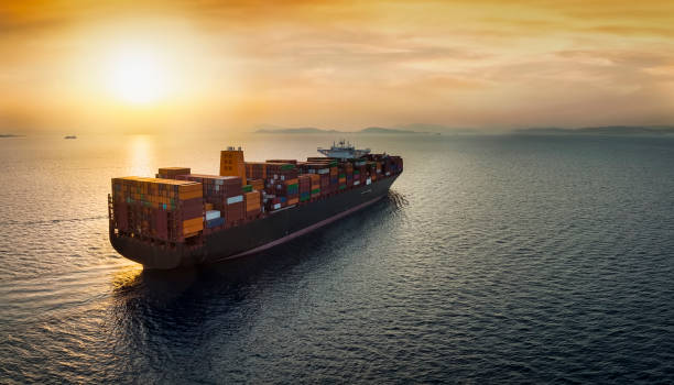 istock Aerial view of a large, heavy loaded container cargo ship sailing into sunset 1416945705