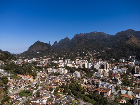 Aerial view of the city of Teresópolis. Mountains and hills with blue sky and many houses in the mountain region of Rio de Janeiro, Brazil. Drone photo. Araras, Teresópolis. Sunny day. Sunrise.