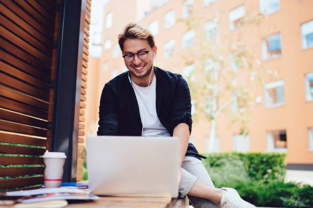istock Satisfied hipster watching laptop taking break in street 1416947240
