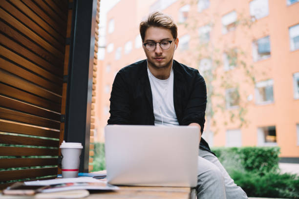 istock Focused man surfing laptop in city 1416947267