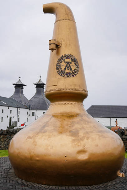 Old copper still in front of the Ardbeg Scotch whisky distillery on Islay stock photo