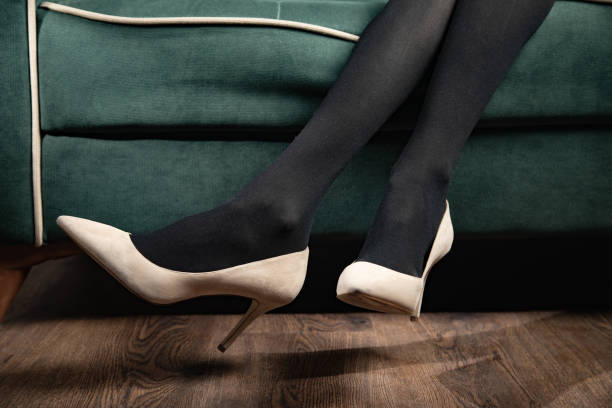 woman in  long legs and shoes sitting in sofa
