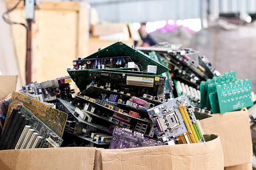 Front shot of cardboard boxes full of obsolete motherboards in electronic recycling plant