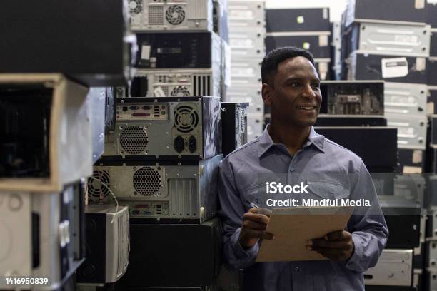 African American Male Worker Taking Inventory At Ewaste Recycling Center Stock Photo - Download Image Now