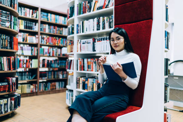 istock Asian female student sitting in library 1416953075
