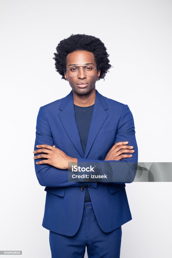 Confident businessman with arms crossed Portrait of confident businessman wearing navy blue suit standing with arms crossed against white background. Manager Stock Photo