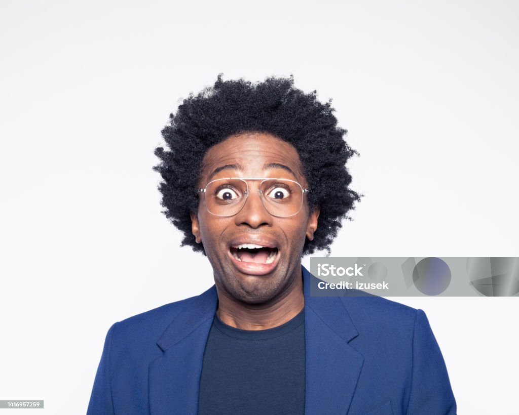 Frightened man staring at camera Headshot of terrified man wearing navy blue suit jacket looking at camera with mouth open. Studio shot against white background. Fear Stock Photo