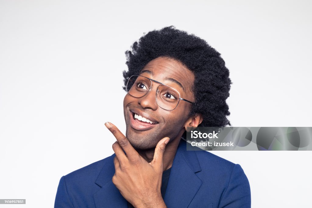 Surprised businessman looking away Headshot of excited businessman wearing navy blue suit jacket looking away with hand on chin. Studio shot against white background. 30-34 Years Stock Photo