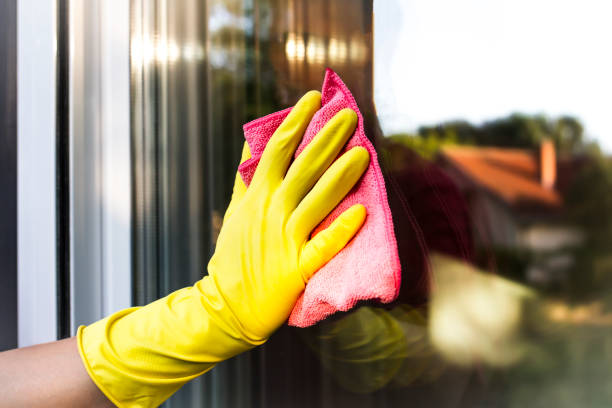 A man's hand with protective glove cleaning the glass window pane A hand in yellow protective glove cleaning the glass window pane with a pink rag. Home routine. washing windows stock pictures, royalty-free photos & images