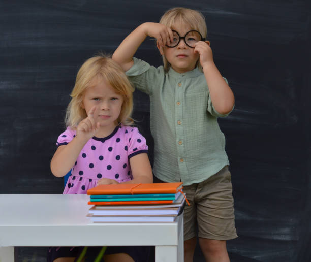 istock Back to school. Two happy elementary school children at the blackboard are ready for the start of the school year. Educational concept. 1416967762