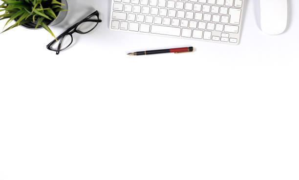 Flat lay of top view desk work table with computer notebook and pencil work space in minimal white tone concept includes copyspace for add text or graphic