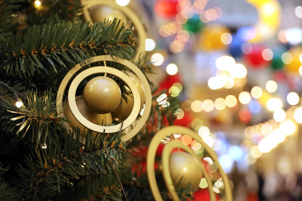 Christmas tree with golden toys in a shopping mall on background of blurred festive lights stock photo