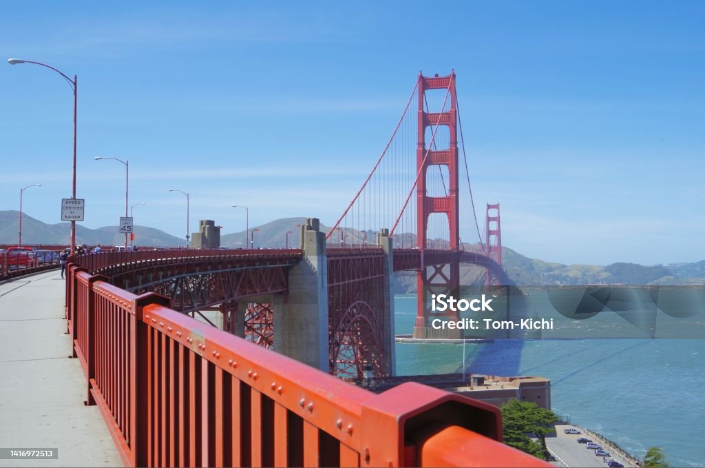 Golden Gate Bridge under the blue sky San Francisco, CA,USA - Apr,29, 2013: 
The Golden Gate Bridge is a suspension bridge that spans the Golden Gate Strait, which connects San Francisco Bay on the west coast of the United States to the Pacific Ocean.Total length 2737 meters. The main tower is 227 meters above the water surface.
There is a promenade in this bridge, we will be able to walk across or bicycle. California Stock Photo