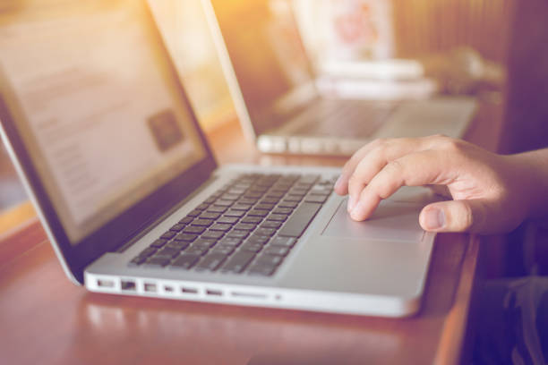 istock Hand on touchpad of laptop in back light on notebook with his finger, toned with sunlight using,gadgets recreation time in coffee shop,vintage color,selective focus. 1416992553