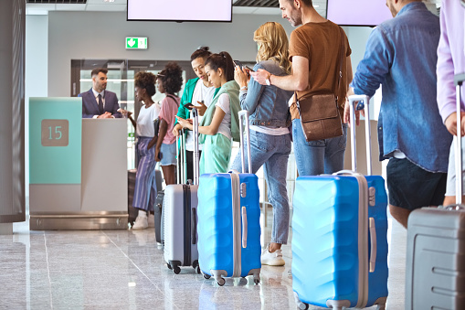 istock Passengers with luggage waiting in line 1417005566