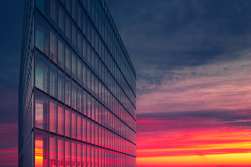 A modern office building facade at sunset.