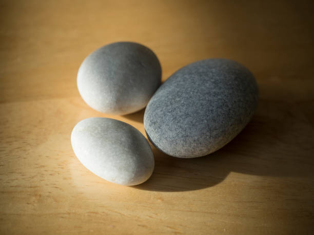 istock three pebbles - white and grey on natural wood desk 1417007232