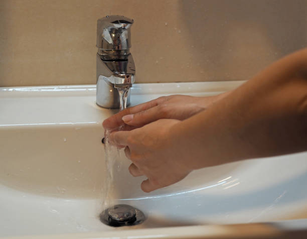 istock washing hands in bathroom sink 1417007443