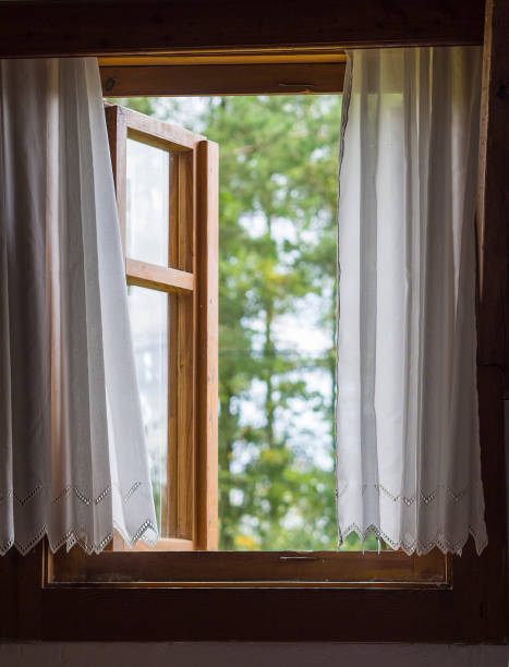 istock rustic wooden window with white curtains with view on defocused green trees 1417009557