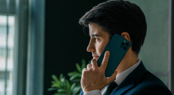 istock Businessman in suit with mobile phone in hands. Man typing message, using social net. Checking news. Making business meeting. Modern office.General manager,ceo.Calling to partner.Planning working day 1417010178