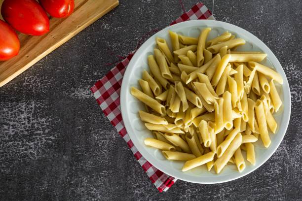 istock typical italian penne pasta on dark stone background 1417012215