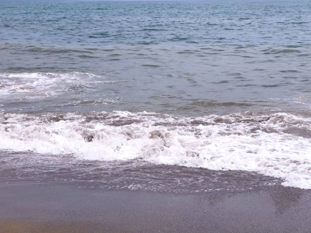 istock A gentle sea wave on a sandy beach 1417013406