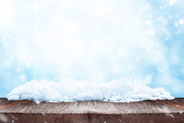 istock Winter or christmas background. Empty wood table over blue background with snow. 1417013438