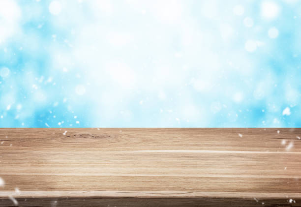 istock Winter or christmas background. Wood table with blank space over blue background with snow. 1417013449