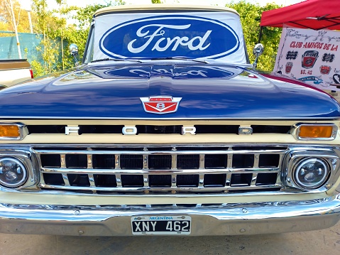 Ford blue oval logo and brand on the windshield of an old F100 V8 utility pickup truck 1963. Front View. Expo Fierros 2022 classic car show