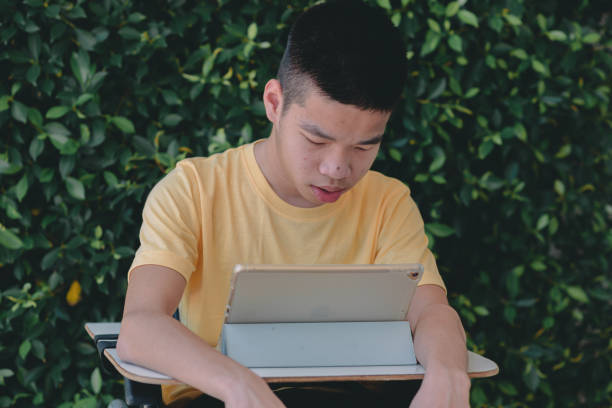 istock Young man with disabilities on wheelchair using mobile phone, Technology for life concept. 1417017218