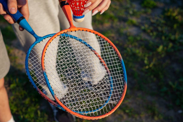 istock guy and girl holding badminton rackets over grass 1417020371