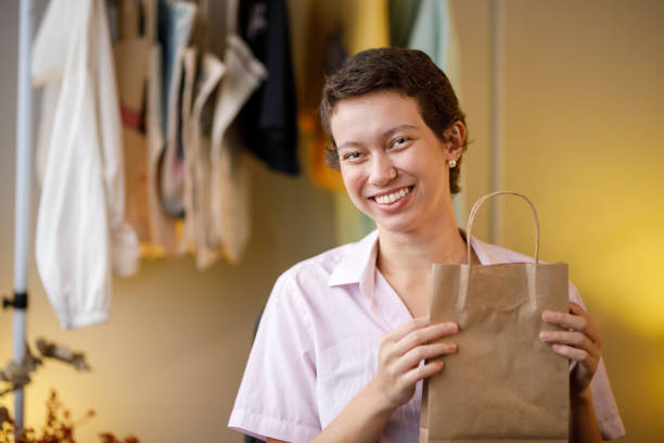 istock Artisan holding a kraft bag and looking at camera 1417020575