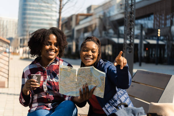 istock Two African girls on vacation enjoying a coffee break and exploring the map 1417021689