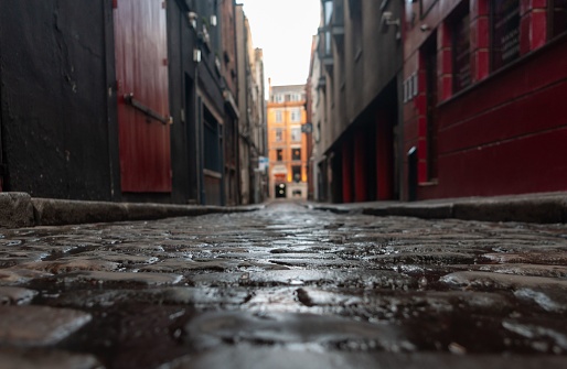 A selective focus of a paved street between old houses on a rainy day in Dublin, Ireland
