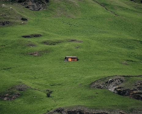 A light glimmering in the small lonely house in the middle of a green field