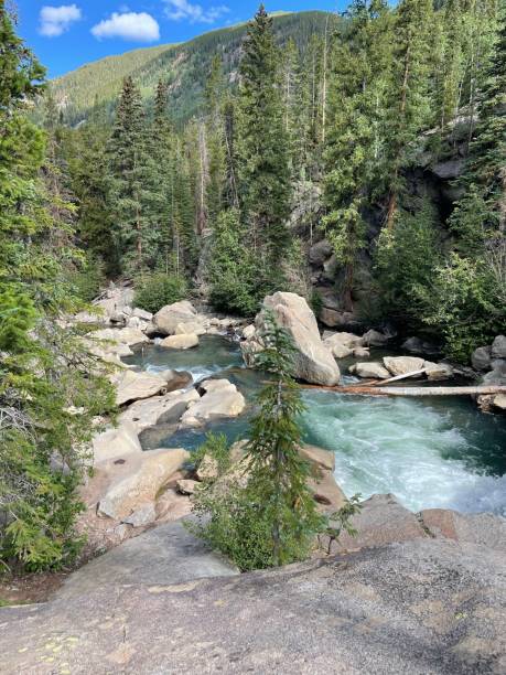 istock Vertical shot of a blue stream on the rocks in a forest 1417026575