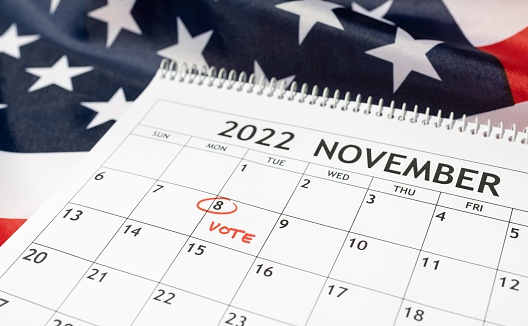 Desk calendar with November 8 2022 marked in red on USA flag background. Vote day concept