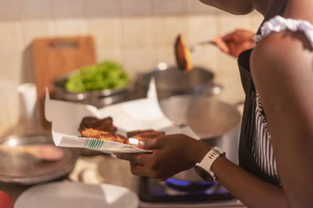 African young woman frying plantain fruit at home
