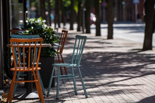 A table with cute yellow and blue chairs on the corner of the street