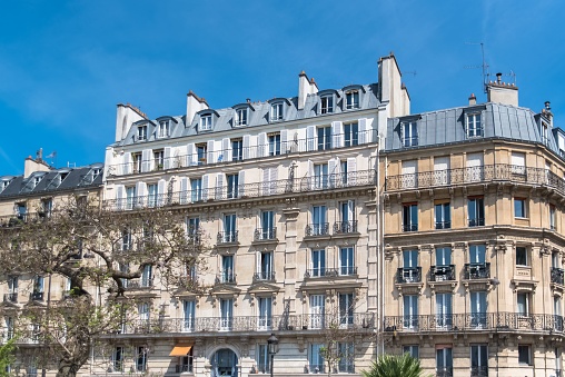 Characteristic Parisien architecture: detail of the facade of a building. Traditional lantern in the foreground (in the sunshine)