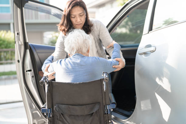 Asian senior or elderly old lady woman patient sitting on wheelchair prepare get to her car, healthy strong medical concept. Asian senior or elderly old lady woman patient sitting on wheelchair prepare get to her car, healthy strong medical concept. senior adult car nurse physical impairment stock pictures, royalty-free photos & images